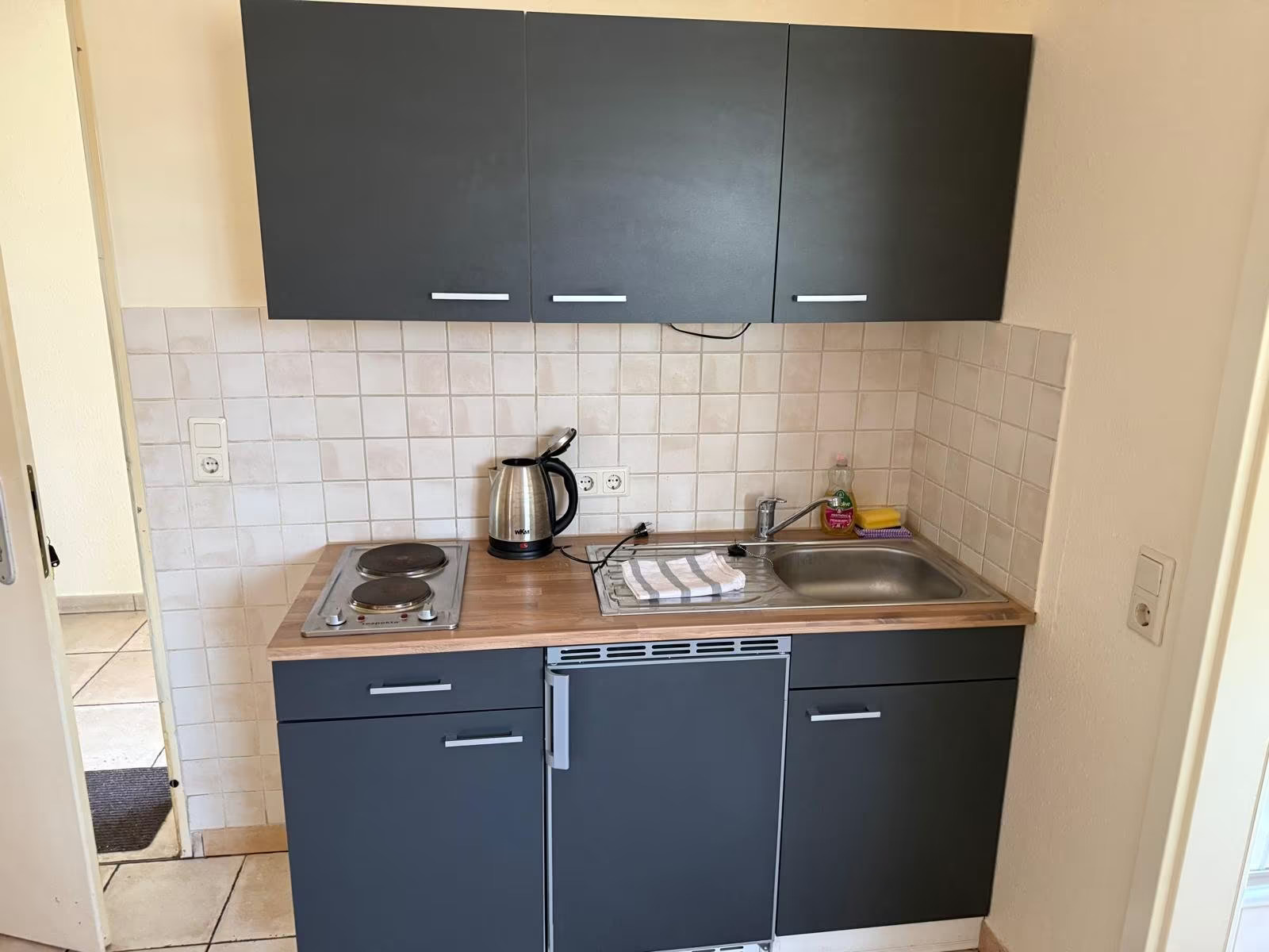 Vollständig ausgestattete Küche mit Herd, Kühlschrank und allen notwendigen Utensilien